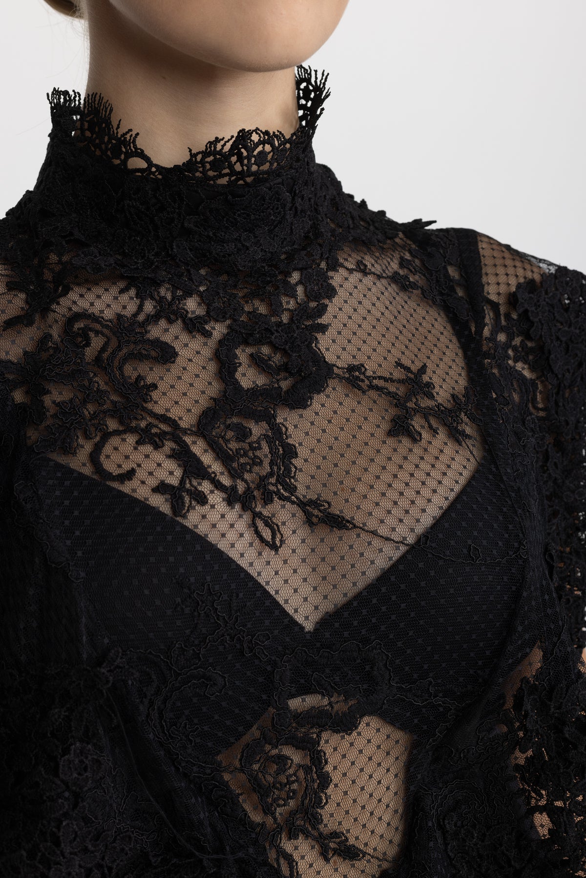Top in pizzo trasparente con collo alto e ruches - Nero