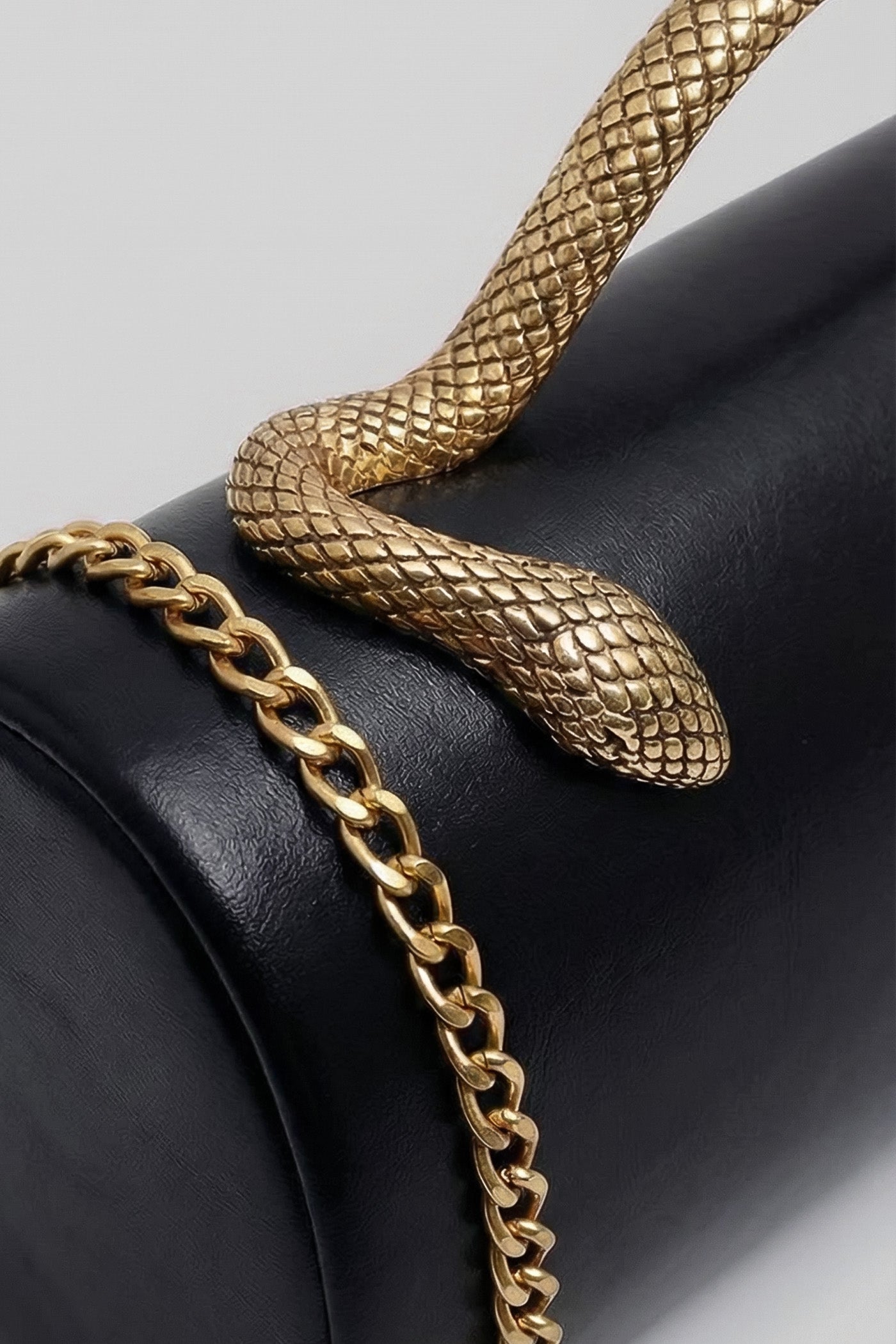 Clutch strutturata con manico in pelle di serpente e catena dorata – Nero