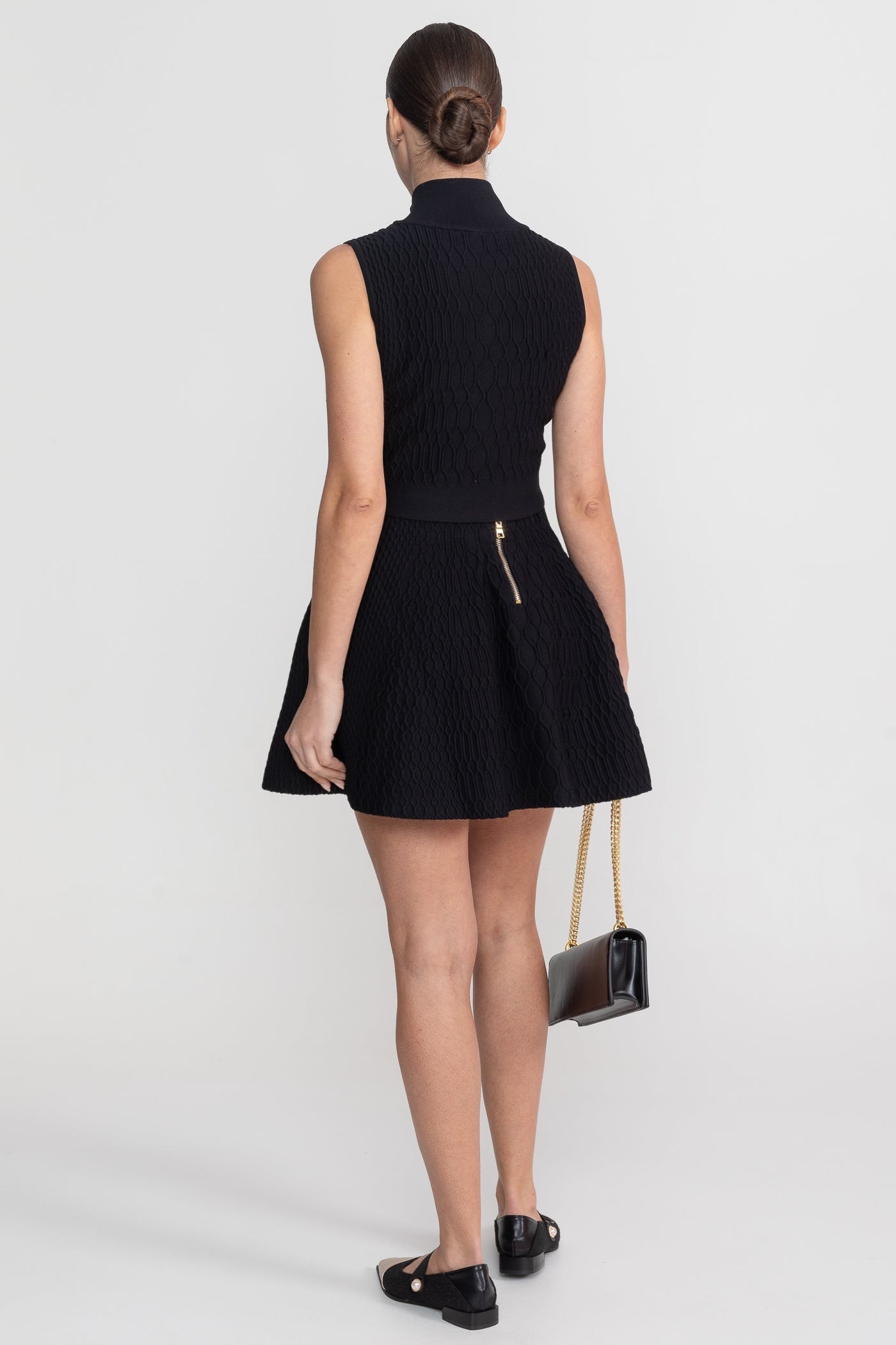 Completo coordinato in tessuto strutturato con top senza maniche a collo alto e minigonna abbinata - Nero 