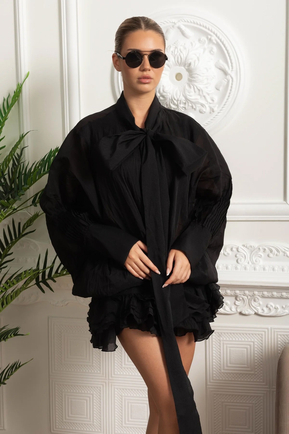 Mini abito nero con volant e fiocco al collo in tessuto trasparente 