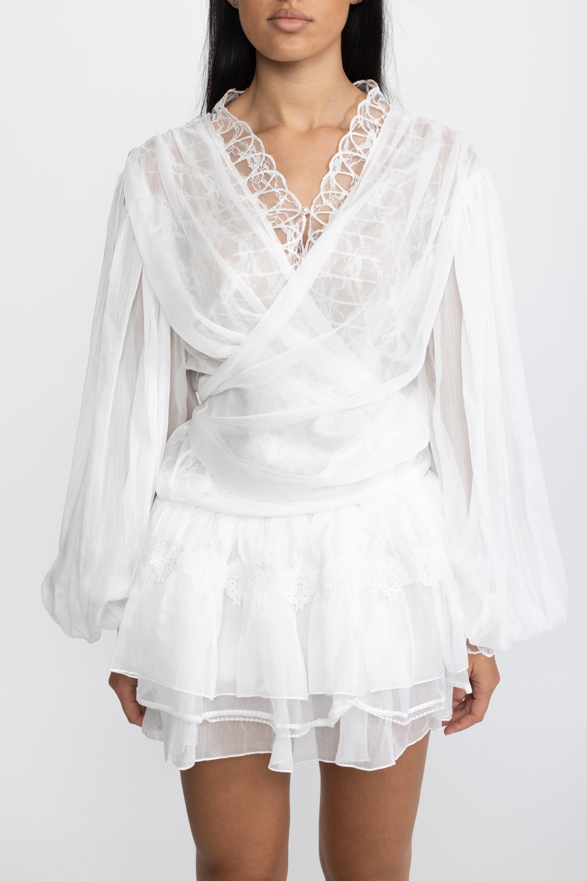 Completo coordinato con blusa a portafoglio in chiffon con inserto in pizzo e minigonna con volant - Bianco 